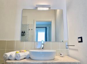 a bathroom with a sink and a mirror and towels at Domu Su Neulaghe in Villasimius