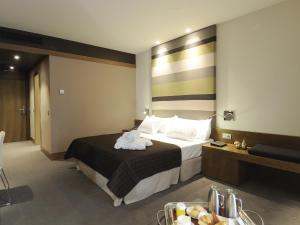 
a hotel room with a bed, table, and nightstand at Las Caldas by blau hotels in Las Caldas

