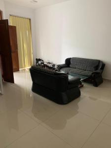 a black couch and a chair in a room at R&R residencies in Mount Lavinia