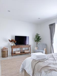 sala de estar con TV, cama y silla en White Castle, en Panwa Beach