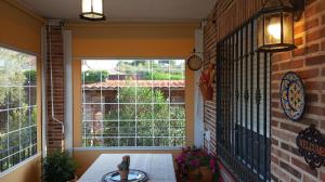 una veranda con tavolo e una grande finestra di Casa Rural Dani Escalona a Toledo