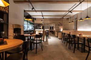 Hotel Schwarz في Nové Hamry: مطعم بطاولات وكراسي خشبية