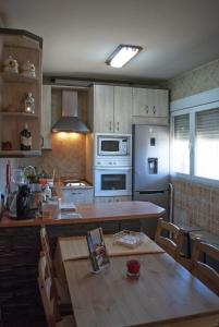 a kitchen with a table and a stove top oven at Casa Rural Dani Escalona in Toledo