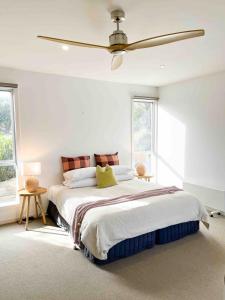 a bedroom with a large bed with a ceiling fan at Pitcher Vista in Port Campbell