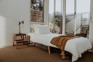 Un dormitorio con una cama grande y una ventana en Pitcher Vista, en Port Campbell