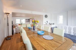 a dining room with a wooden table and white chairs at The Roof Terrace Maisonette - City Centre in Bath