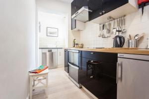 a kitchen with black cabinets and stainless steel appliances at The Roof Terrace Maisonette - City Centre in Bath