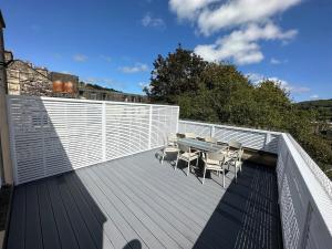 a deck with a table and chairs on it at The Roof Terrace Maisonette - City Centre in Bath