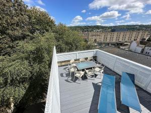 a patio with a table and chairs on a roof at The Roof Terrace Maisonette - City Centre in Bath +35 photos