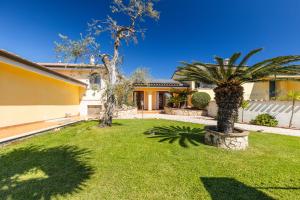a house with two palm trees in a yard at VILLE MONDO a 350 metri dalla spiaggia in Àrbatax