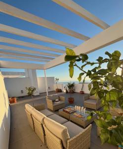 a patio with a couch and chairs and a table at Amazing Penthouse in Costa del Sol in Rincón de la Victoria