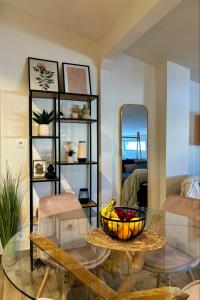a living room with a glass table and a bowl of fruit at Maya Suites N.Moudania in Nea Moudania +16 photos