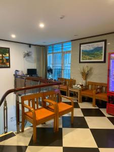 uma sala de estar com cadeiras de madeira e um piso em xadrez em A25 Hotel - Đội Cấn 2 em Hanói