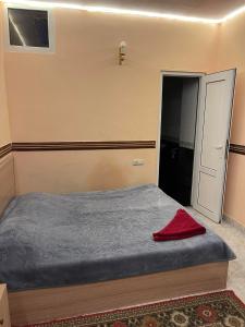 a small bedroom with a bed and a door at CITRUS Guest House in Yerevan