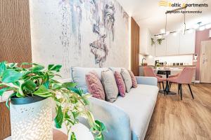 a living room with a white couch with pillows at Baltic Apartments - Matejki 17 in Świnoujście