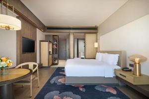西安市にあるInterContinental Xi'an Hi-Tech Zoneのベッドとテーブルが備わるホテルルームです。