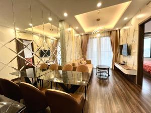 sala de estar con mesa de cristal y sillas en X-Stay, en Hai Phong