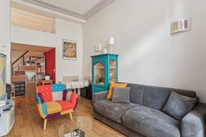 uma sala de estar com um sofá e uma cadeira em Charmant appartement en plein coeur du Marais em Paris