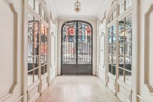 um corredor vazio com uma porta e janelas em Charmant appartement en plein coeur du Marais em Paris