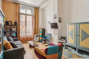 uma sala de estar com um sofá e uma televisão em Charmant appartement en plein coeur du Marais em Paris