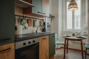 a kitchen with a sink and a stove and a table at Una casa a San Giacomo x2 in Trieste