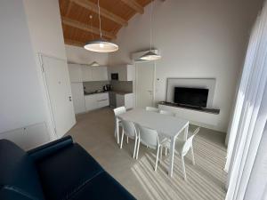a living room with a white table and chairs at Woody Green Penthouse Sea View - Agenzia Cocal in Caorle