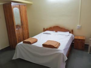 una camera da letto con un letto con due asciugamani sopra di Anand Nivas a Malwan