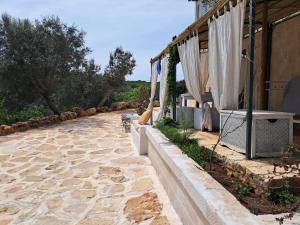 a stone walkway next to a building with curtains at Conibianchi Lamia&YurtArt House in Ceglie Messapica