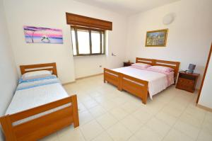 a bedroom with two beds and a window at Oasi Residence in Marina San Gregorio