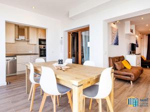 a kitchen and dining room with a wooden table and chairs at Apto Las Palmeras in Platja  d'Aro