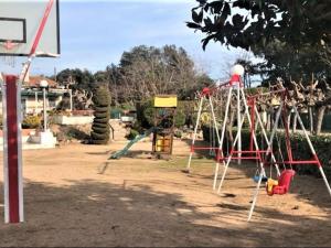 a playground with a swing set in a park at Apto Las Palmeras in Platja  d'Aro