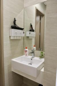 ein Badezimmer mit einem weißen Waschbecken und einem Spiegel in der Unterkunft Homestay Ocean Park Căn 2N full đồ xịn đẹp S1.03 in Gia Lâm Pho