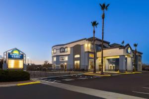 a building with a palm tree in front of it at Days Inn & Suites by Wyndham Tucson/Marana in Tucson