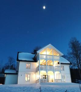 a large white house in the snow at night at Magnor House in Eidskog, Hedmark close to The Plus and Magnor Glassverk in Magnor