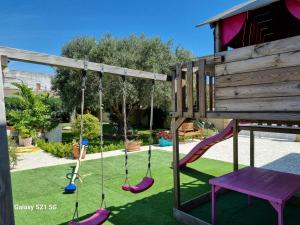 une aire de jeux avec une balançoire et un banc dans l'établissement Villa Calipso - Appartamento in Villa con giardino e wi-fi, à Ovile la Marinella
