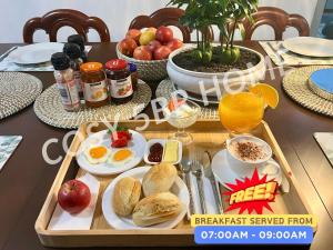 a breakfast tray with eggs bread and fruit on a table at Cosy 5BR Home 10 minutes away from Melbourne Airport in Albion