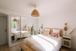 a white bedroom with two beds and a mirror at Mas des Arts & Spa in La Colle-sur-Loup +48 photos