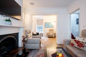 a living room with a couch and a fireplace at Spacious, Bright & Cosy ~ Ideal Victoria Location! in London
