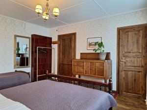 Schlafzimmer mit einem Bett, einer Kommode und einem Spiegel in der Unterkunft Kraavi Guest Hostel in Kuressaare