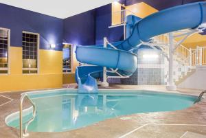 a large pool with a water slide in a building at Ramada by Wyndham Red Deer Hotel & Suites in Red Deer