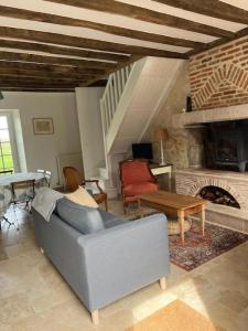 sala de estar con sofá y chimenea en La Tibourdière : au coeur du pays des châteaux, maison au calme entre vignes et champ, en Cheverny