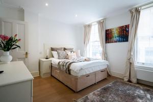 ein Schlafzimmer mit einem Bett und einem Wandgemälde in der Unterkunft Spacious, Bright & Cosy ~ Ideal Victoria Location! in London