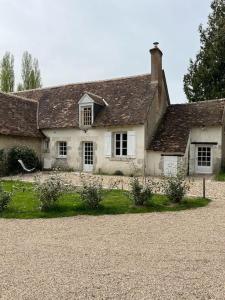 una antigua casa blanca con una pared de piedra en La Tibourdière : au coeur du pays des châteaux, maison au calme entre vignes et champ, en Cheverny