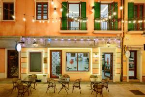 a restaurant with tables and chairs in front of a building at BELLA HOTEL PHU QUOC -Sunset Town, Địa Trung Hải- BIG PROMOTION 2024 in Phu Quoc
