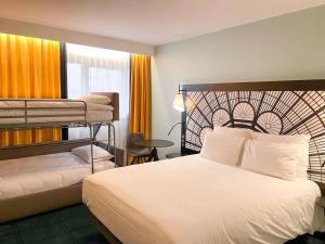 a hotel room with a bed and bunk beds at Mercure Paris Porte De Versailles Expo in Paris