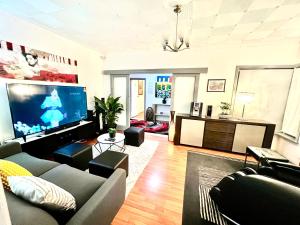 a living room with a couch and a flat screen tv at Cosy 5BR Home 10 minutes away from Melbourne Airport in Albion