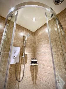 y baño con ducha y puerta de cristal. en Spean Lodge, en Spean Bridge