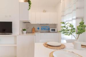 a white kitchen with white cabinets and a sink at Condominio Rossella in Lido di Jesolo