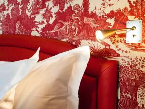 - une chambre avec un lit rouge et une fresque murale dans l'établissement Hotel Le Royal Lyon - MGallery, à Lyon