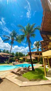 a resort with a swimming pool and palm trees at Pousada Vivenda Oriente in São José da Coroa Grande